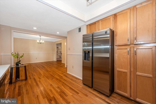 kitchen featuring stainless steel fridge, a chandelier, wood finished floors, baseboards, and recessed lighting