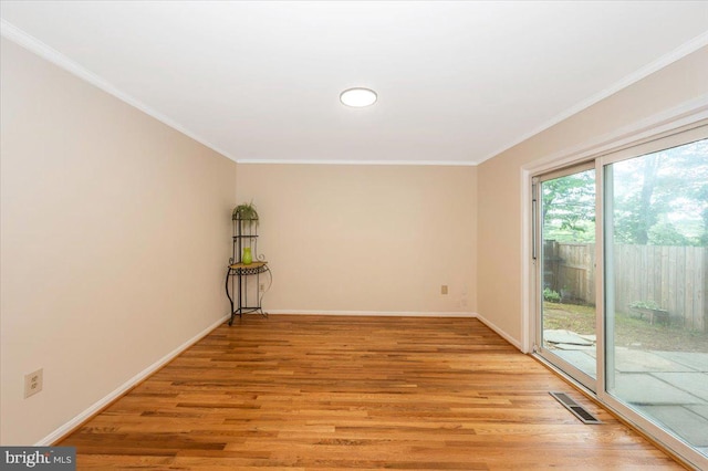 empty room with baseboards, ornamental molding, and light wood-style flooring