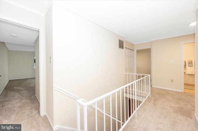 hallway with carpet, an upstairs landing, and baseboards