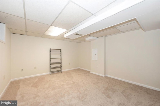 finished below grade area featuring carpet floors, a drop ceiling, and baseboards