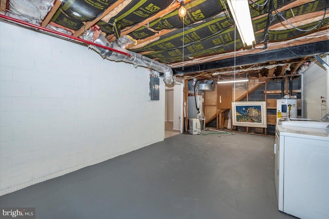 unfinished below grade area with washer / dryer, electric panel, concrete block wall, and water heater