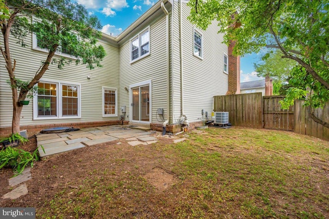rear view of property featuring central AC, fence, and a patio