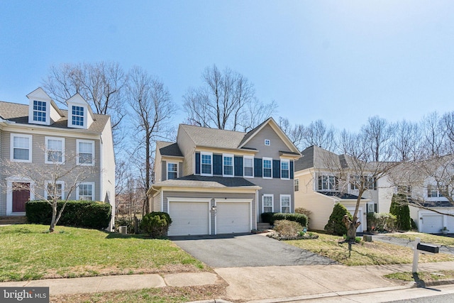 view of front of home with a garage, driveway, and a front lawn