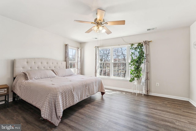 bedroom with ceiling fan, wood finished floors, visible vents, and baseboards