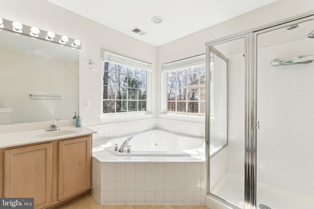 bathroom featuring visible vents, vanity, a jetted tub, and a shower stall