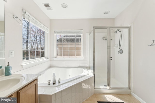 full bath featuring vanity, a jetted tub, visible vents, and a stall shower
