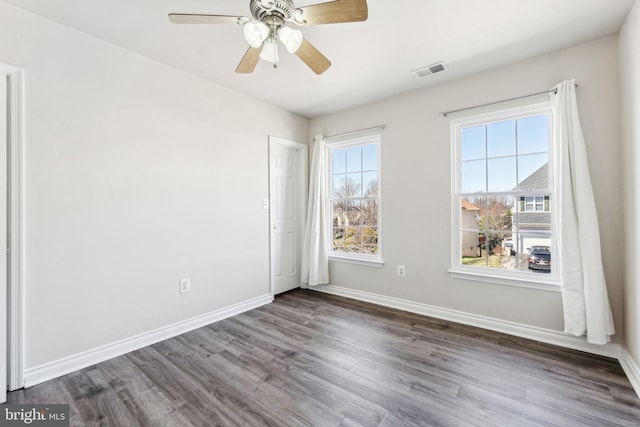 unfurnished room with visible vents, a ceiling fan, baseboards, and wood finished floors