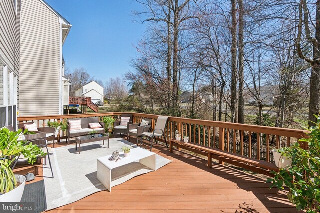 wooden terrace with an outdoor living space
