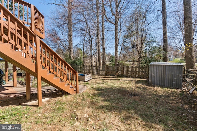 view of yard with stairs, an outdoor structure, a deck, and fence