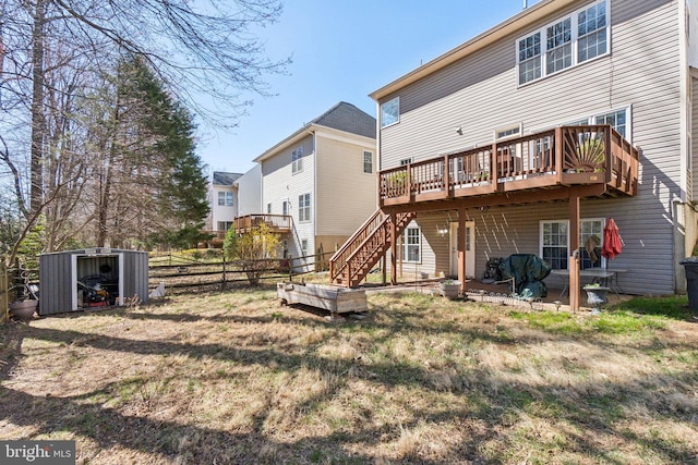 back of property with an outbuilding, a deck, a patio, fence, and stairs