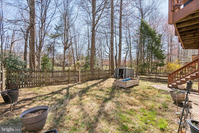view of yard with stairway, a shed, an outdoor structure, and a fenced backyard