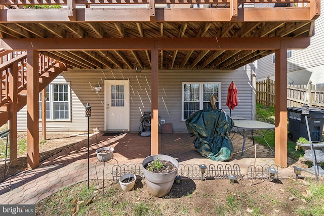 view of patio with stairway and fence