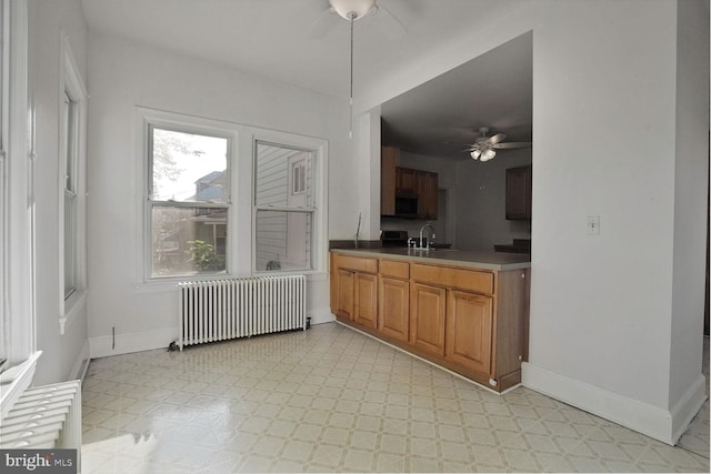 1033 Newton St NE, Washington, DC 20017 - kitchen featuring radiator heating unit, a ceiling fan, stainless steel microwave, light flooring, and brown cabinetry