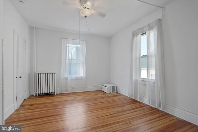 1033 Newton St NE, Washington, DC 20017 - empty room featuring radiator heating unit, healthy amount of natural light, wood finished floors, and a ceiling fan