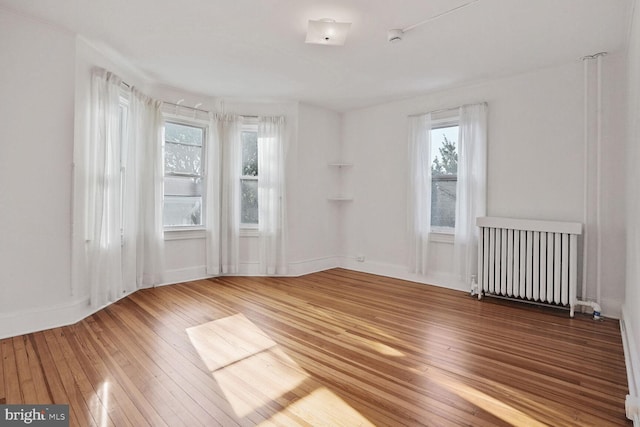 1033 Newton St NE, Washington, DC 20017 - unfurnished room featuring radiator heating unit, wood-type flooring, and a smoke detector