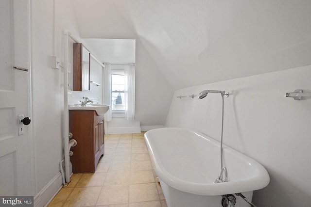 1033 Newton St NE, Washington, DC 20017 - bathroom featuring a freestanding tub, vaulted ceiling, vanity, and tile patterned flooring