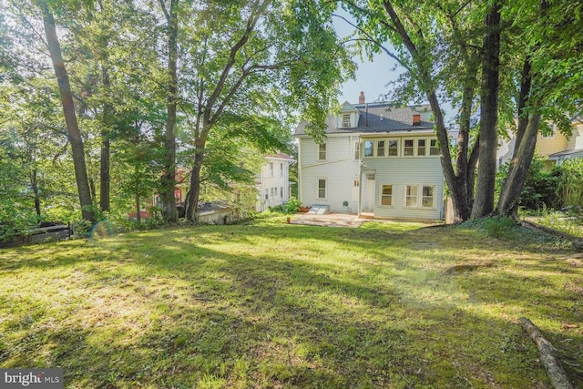 1033 Newton St NE, Washington, DC 20017 - back of house with a lawn, a patio area, and a chimney