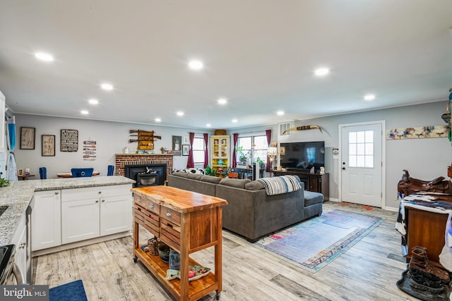 living area featuring recessed lighting, baseboards, and light wood-style floors