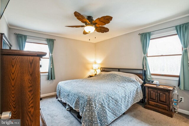 bedroom with baseboards, crown molding, carpet, and a ceiling fan