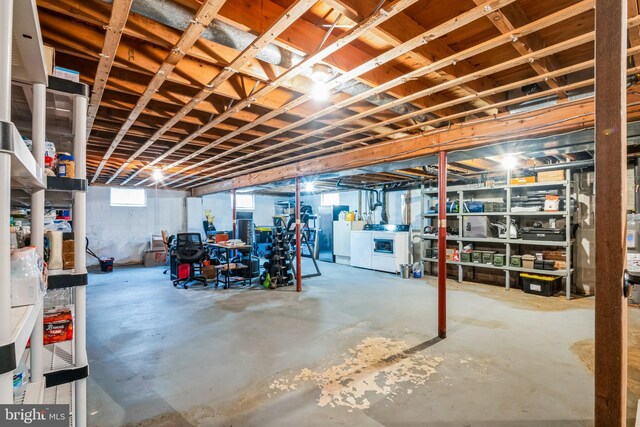 basement with fridge and washing machine and dryer