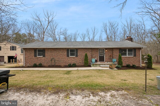 ranch-style home with a front yard, brick siding, and a chimney