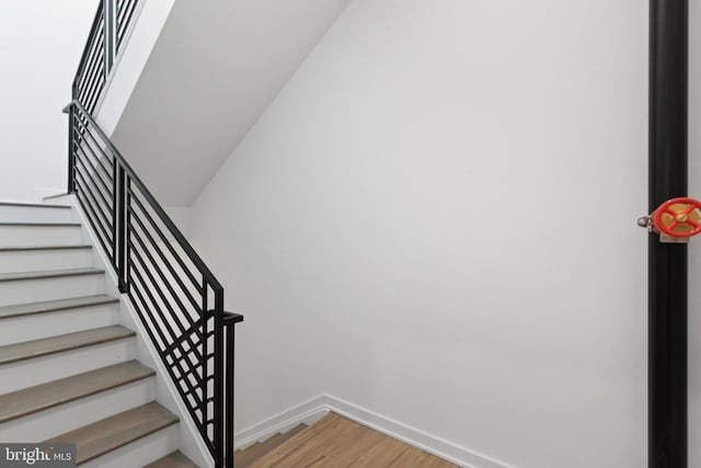 staircase with wood finished floors and baseboards