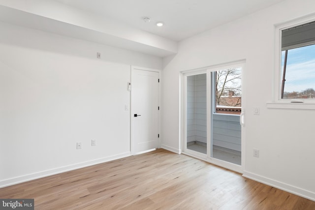 unfurnished room featuring light wood-style floors and baseboards