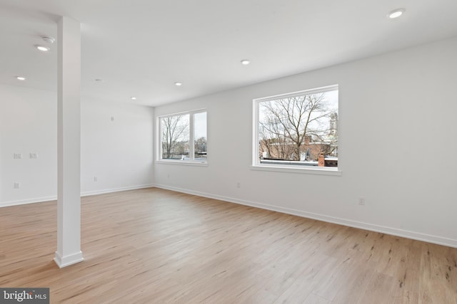 empty room featuring recessed lighting, baseboards, and light wood finished floors