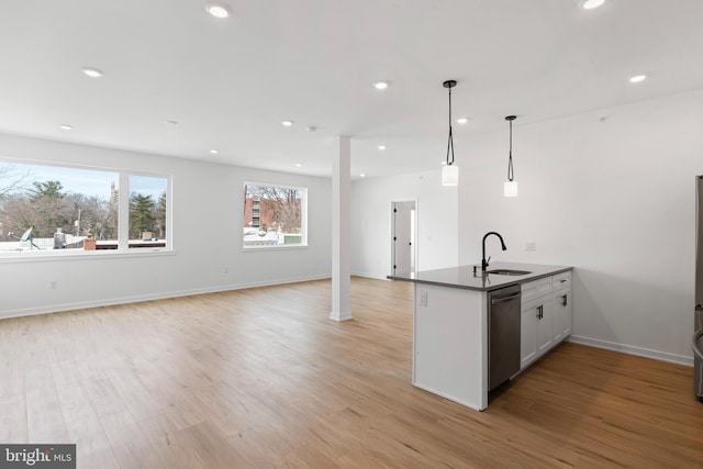 kitchen with a peninsula, recessed lighting, a sink, stainless steel dishwasher, and light wood-type flooring