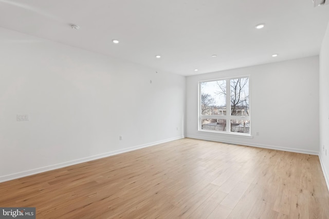 spare room with recessed lighting, baseboards, and light wood-style floors