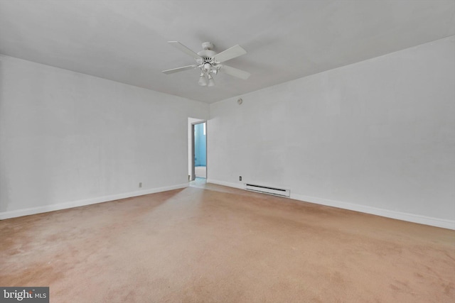 spare room featuring a baseboard heating unit, carpet floors, a ceiling fan, and baseboards