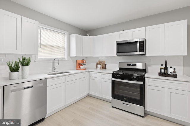 505 N Rose St, Baltimore, MD 21205 - kitchen featuring white cabinets, appliances with stainless steel finishes, light countertops, and a sink