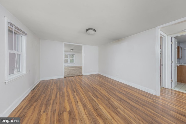 empty room with baseboards and wood finished floors