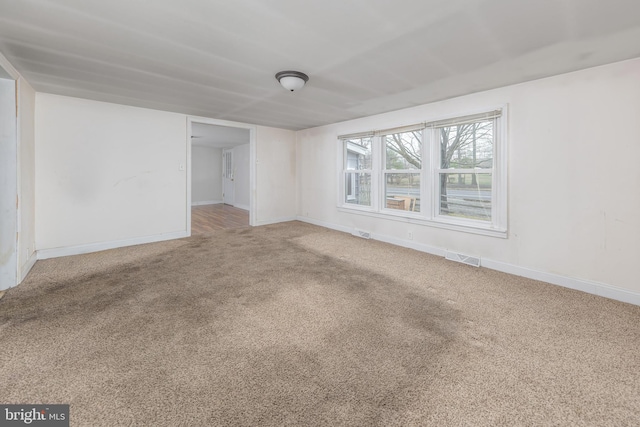 carpeted empty room with visible vents and baseboards