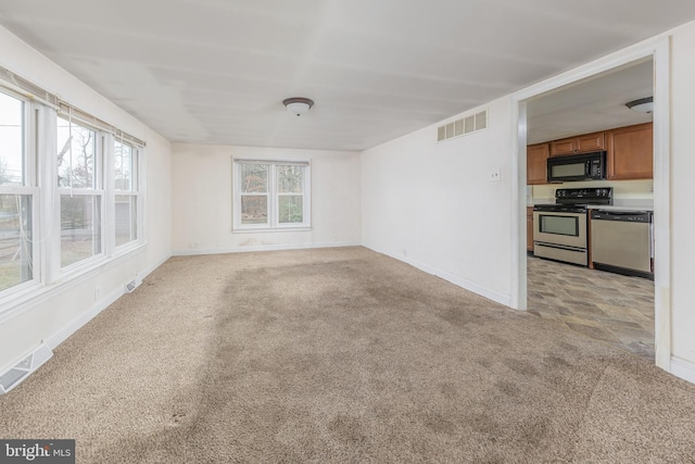 interior space with visible vents, baseboards, and light colored carpet