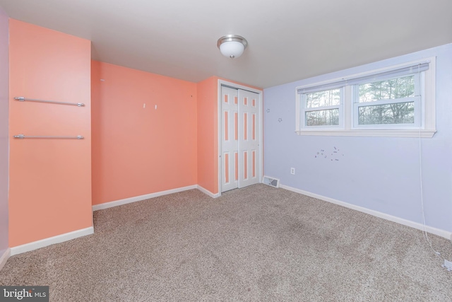 unfurnished room featuring visible vents, baseboards, and carpet floors