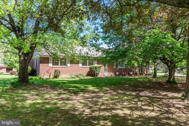 exterior space featuring a front yard and brick siding