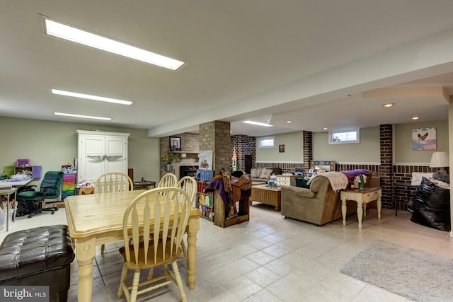 dining room with light tile patterned floors and a fireplace
