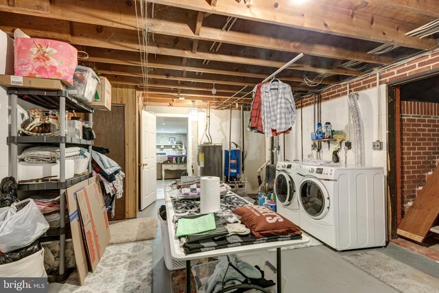 unfinished basement with washing machine and clothes dryer and electric water heater