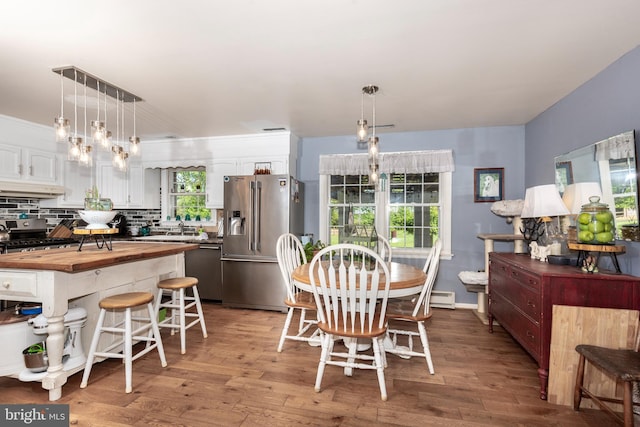 dining area featuring a baseboard radiator and light wood-style flooring
