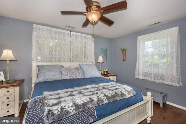 bedroom featuring visible vents, baseboards, ceiling fan, and wood finished floors