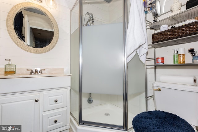 bathroom with toilet, a shower stall, and vanity