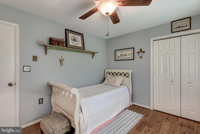bedroom featuring a closet, a ceiling fan, baseboards, and wood finished floors