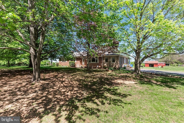 view of front of house featuring a front yard and brick siding