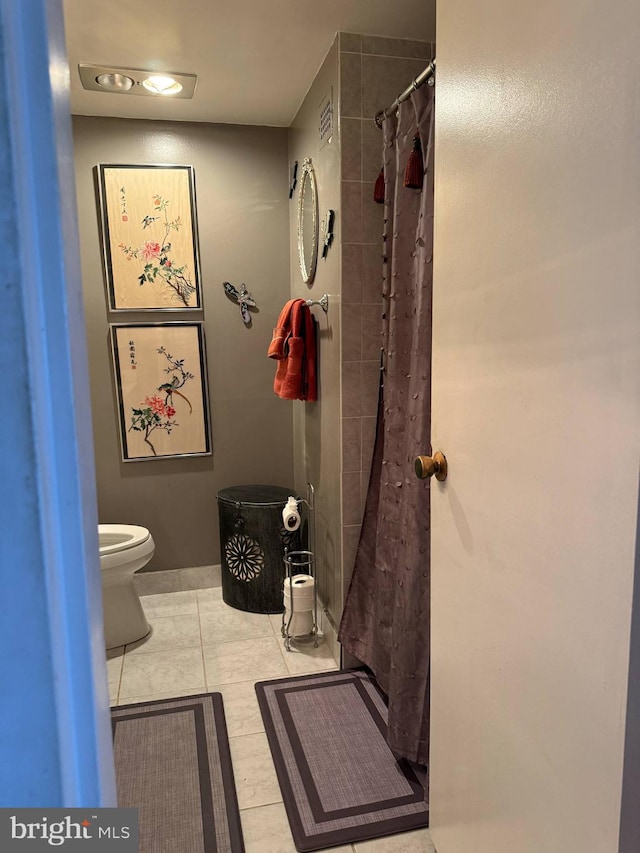 bathroom featuring tile patterned flooring, toilet, baseboards, curtained shower, and visible vents