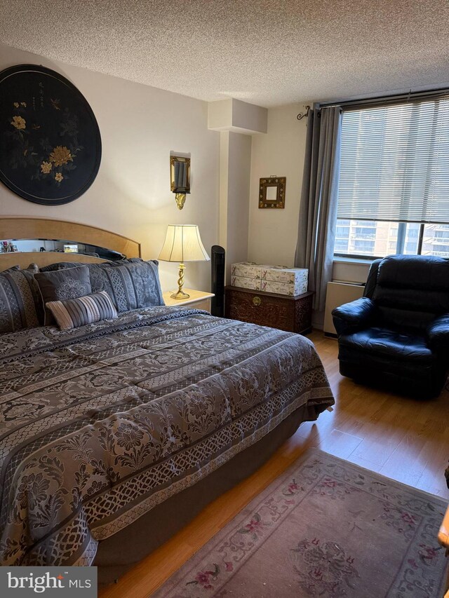 bedroom featuring a textured ceiling and wood finished floors