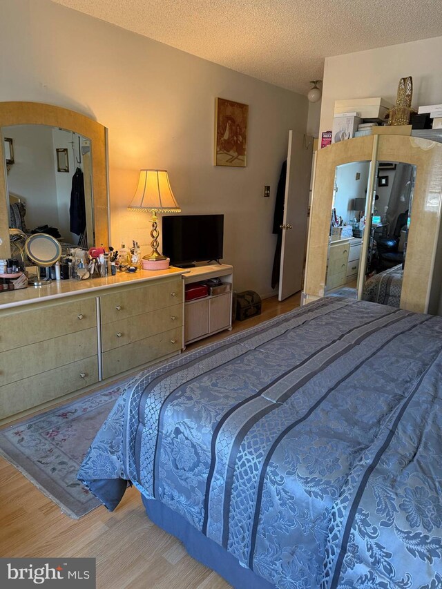 bedroom featuring a textured ceiling and wood finished floors