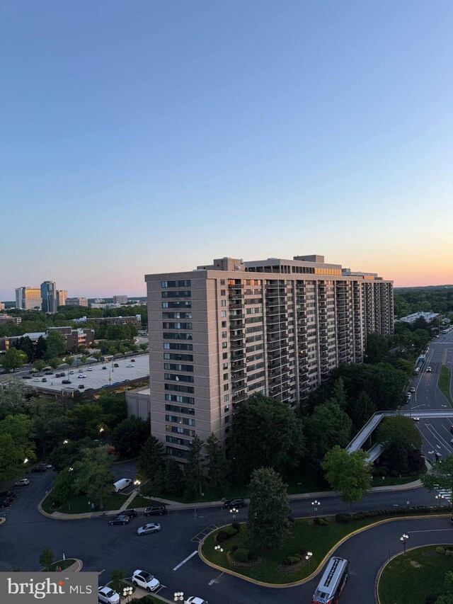 view of property with uncovered parking and a city view