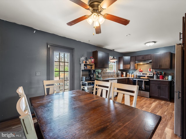 dining area with light wood-type flooring and ceiling fan