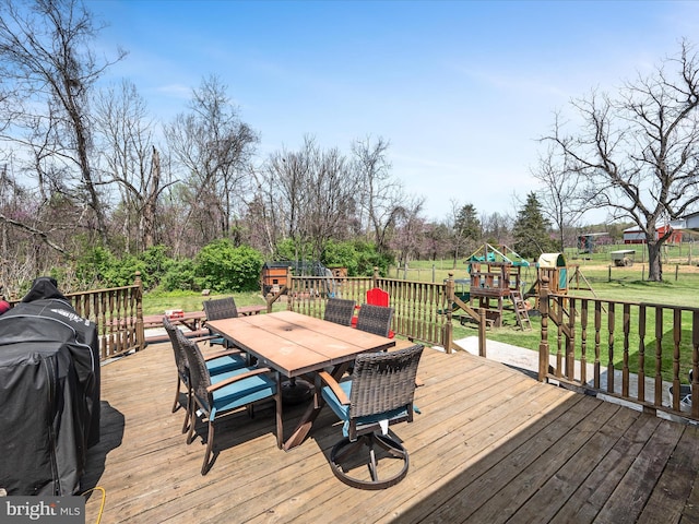 deck with fence, a playground, a yard, and outdoor dining area